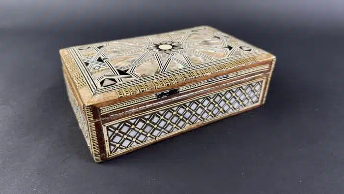 Schatulle, 20. Jahrhundert, Holzkassette mit ornamentaler Edelholz-, Bein- und Perlmuttmarketerie, innen in rotem Stoff staffiert, Scharnierdeckel, ca. 19x12 cm H 7cm, Alters- und Gebrauchsspuren – Bild 7