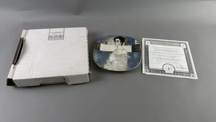 Wandteller, nach Gustav Klimt "Frauenbildnisse", Lilienporzellan Austria, weiß glasiert, Farbdrucke goldgerändert, 21 x 21 cm, limitierte Auflage, nummeriert und beschriftet,  mit Zertifikat, guter Erhaltungszustand OVP – Bild 2