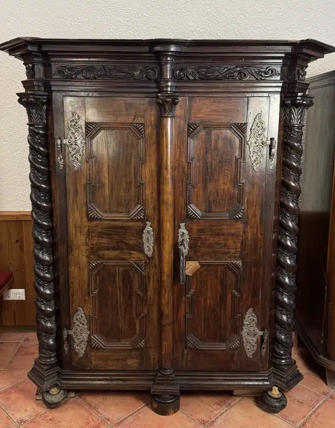 Provinzieller Barockhallenschrank, massiver Korpus, braun mattiert, mit gewunden gedrechselten Säulen geziert, in feiner Qualität ornamental sowie in Form Rranken, 2 Türen, 2 Laden, Schloss, Schlüssel, guter Allgemeinzustand mit schöner Patina, kleinere Teile zu ergänzen, Füße zu restaurieren, mit der Bitte um Besichtigung