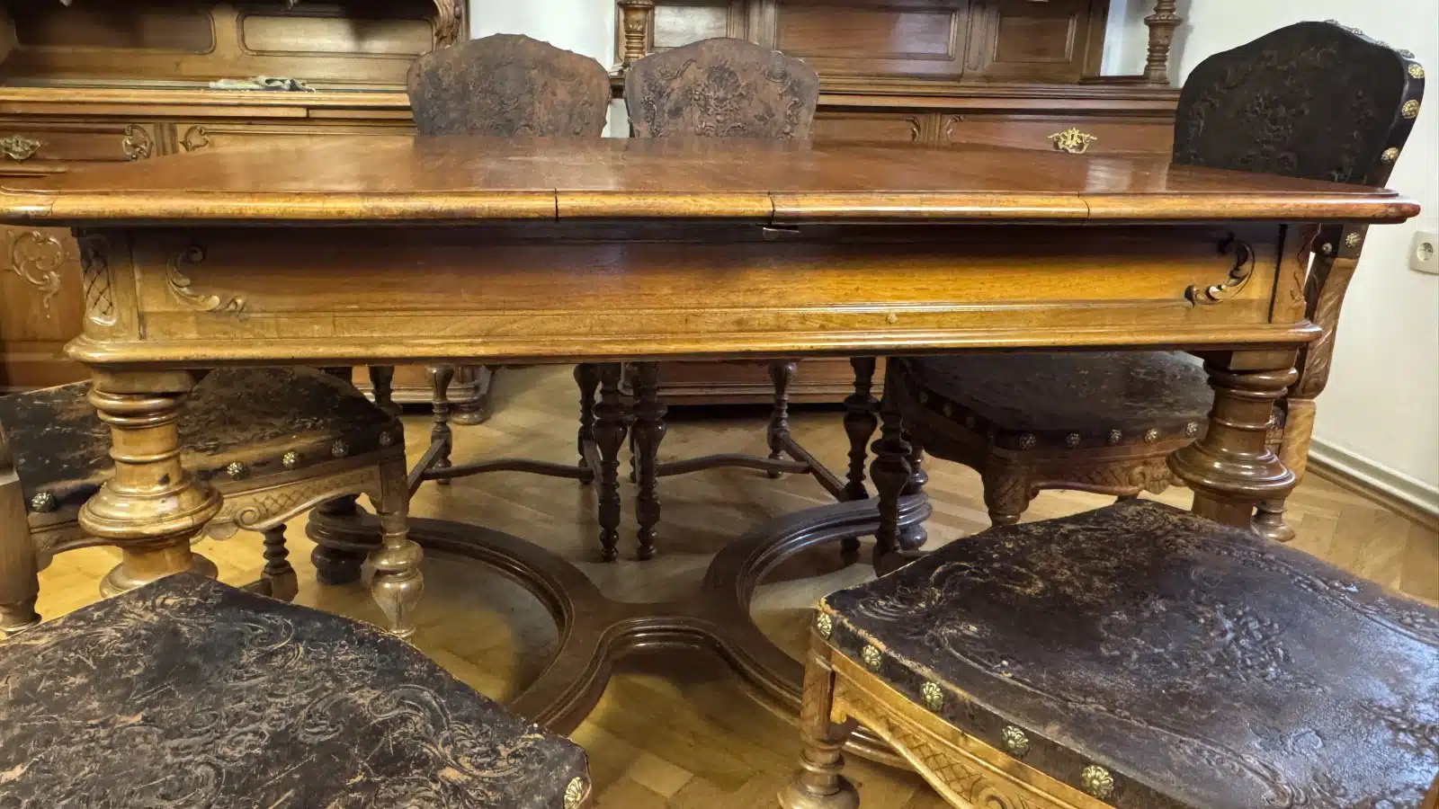 Gründerzeit Speisezimmer Sitzgruppe, um 1880, gedrechselt und plastisch beschnitzt, bestehend aus: 1 rechteckiger Tisch mit Kreuz stegverbindung, Plattengröße 123 x 104 cm, H 79cm zuzüglich 5 Sessel in gleicher Ausführung, Sitze und Lehnteile mit geprägter Lederbespannung, – Bild 4